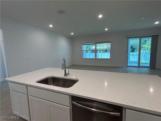 kitchen with a sink, visible vents, open floor plan, stainless steel dishwasher, and light stone countertops