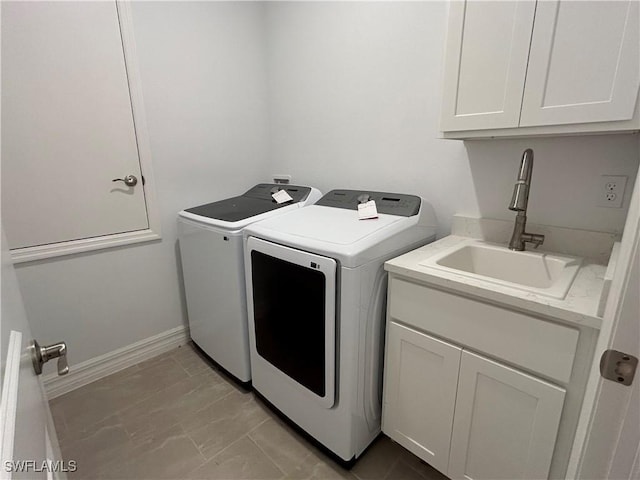 clothes washing area with washing machine and clothes dryer, baseboards, a sink, and cabinet space
