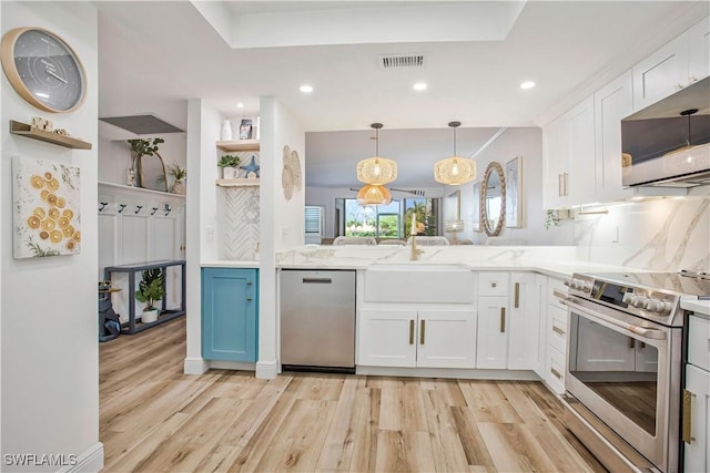 kitchen featuring stainless steel appliances, a sink, light wood finished floors, open shelves, and recessed lighting