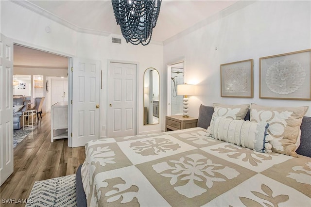 bedroom featuring wood finished floors and a chandelier