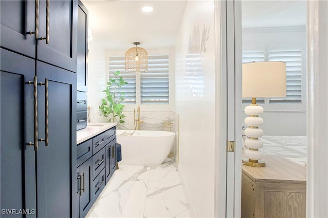 bathroom with marble look tile flooring, a freestanding bath, vanity, and recessed lighting