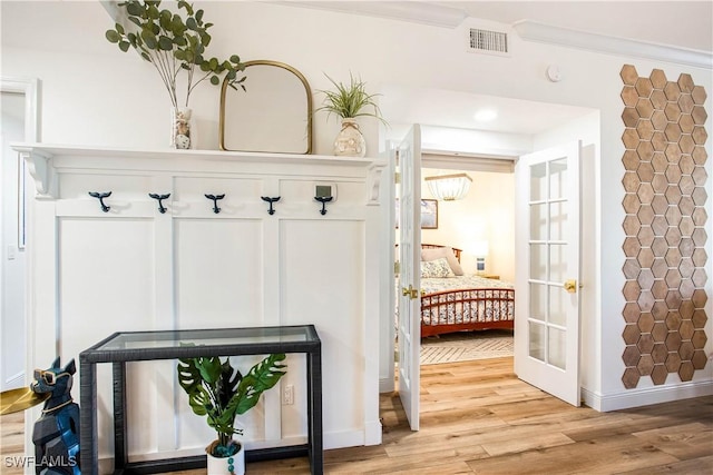 mudroom with light wood-type flooring, baseboards, and french doors