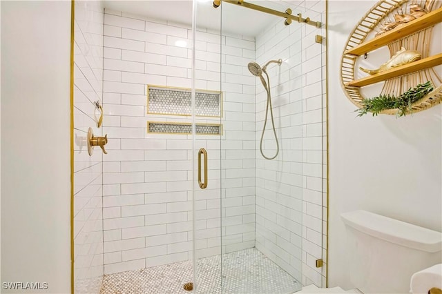 bathroom featuring toilet and a stall shower