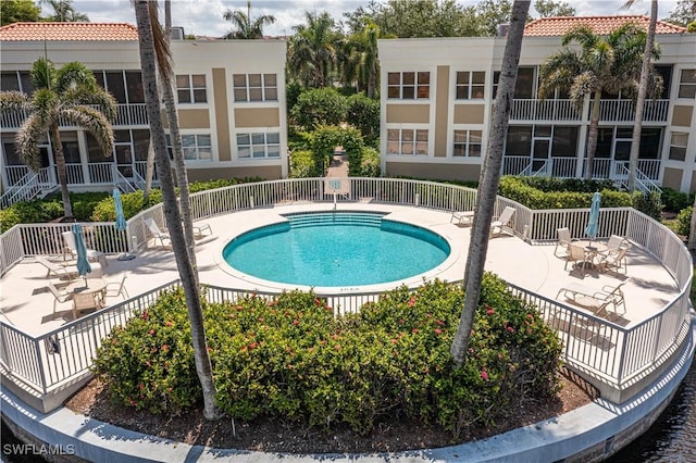 community pool featuring fence and a patio
