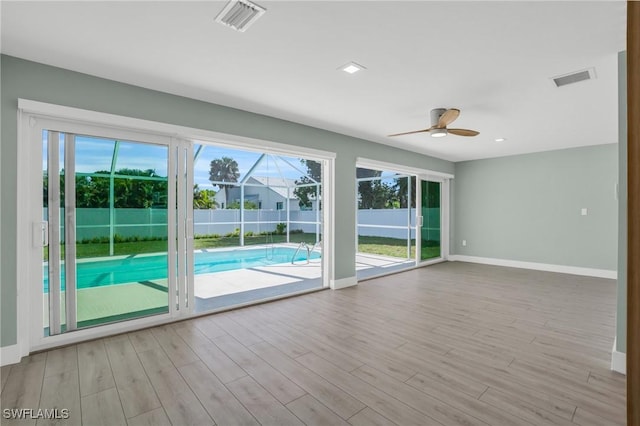 interior space featuring ceiling fan, baseboards, visible vents, and wood finished floors