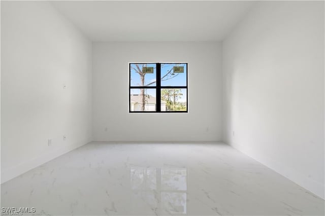 unfurnished room with baseboards and marble finish floor
