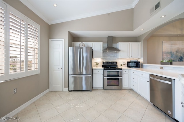 20930 Island Sound Cir Unit 402, Estero, FL 33928 - kitchen featuring appliances with stainless steel finishes, wall chimney exhaust hood, arched walkways, decorative backsplash, and light countertops