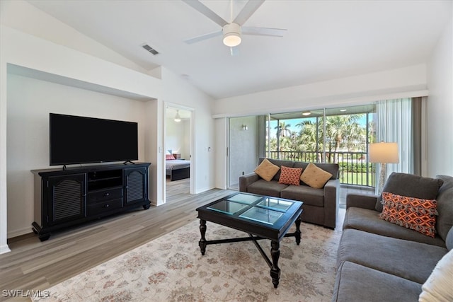 living room featuring wood finished floors, ceiling fan, vaulted ceiling, and baseboards