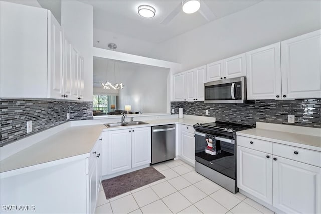 kitchen featuring appliances with stainless steel finishes, a sink, decorative backsplash, light tile patterned flooring, and white cabinetry