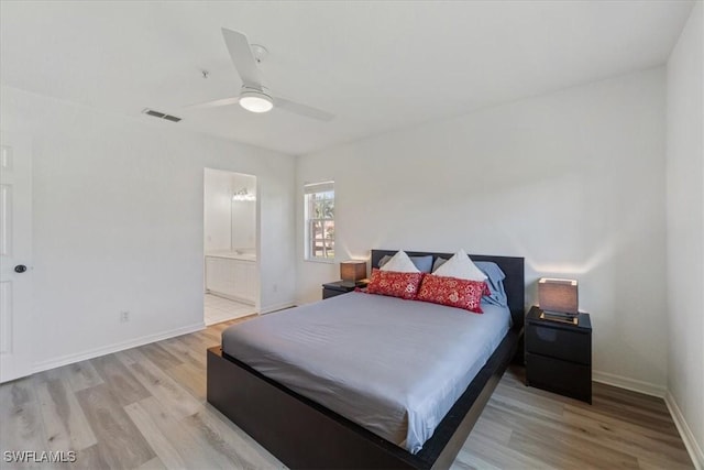 bedroom featuring wood finished floors, baseboards, ensuite bath, and ceiling fan