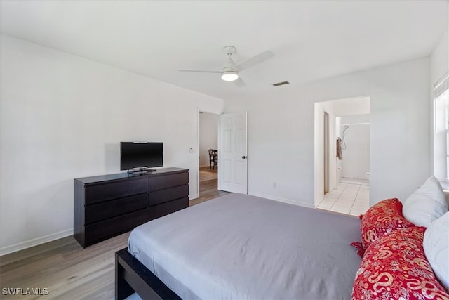bedroom featuring baseboards, ceiling fan, light wood-type flooring, and connected bathroom