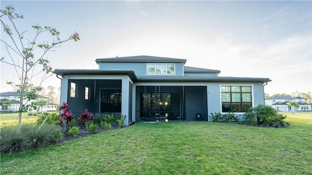 back of house featuring a yard and a sunroom