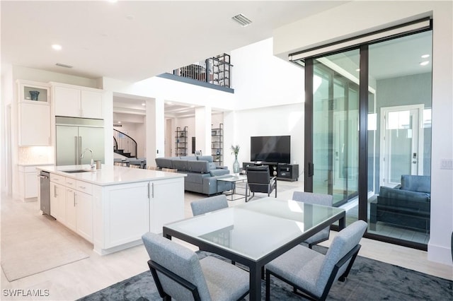 dining area featuring recessed lighting, visible vents, light wood-style flooring, and stairs