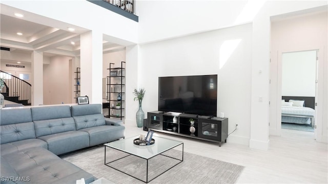 living room featuring stairs, a high ceiling, baseboards, and recessed lighting