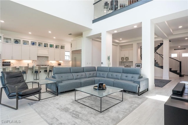 living room with light wood-style floors, stairway, and recessed lighting
