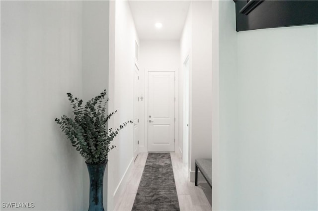 corridor featuring light wood-style floors, baseboards, and recessed lighting