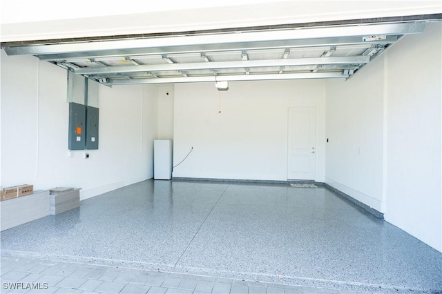 garage featuring electric panel and baseboards