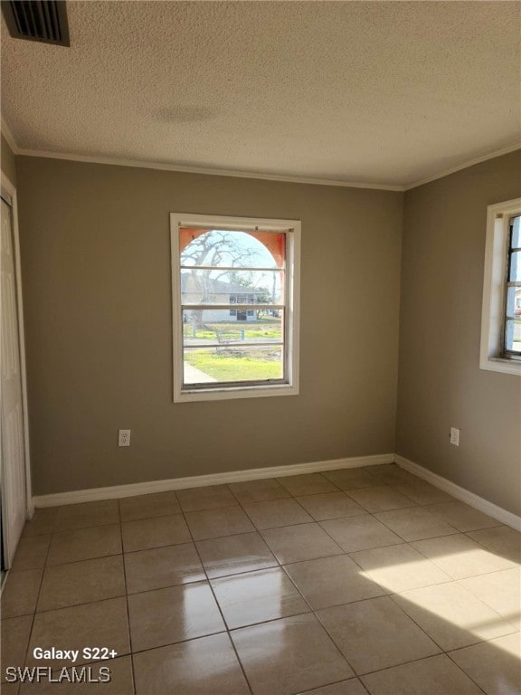 16901 Juanita Ave, Fort Myers, FL 33908 - empty room featuring a textured ceiling, visible vents, tile patterned flooring, baseboards, and ornamental molding