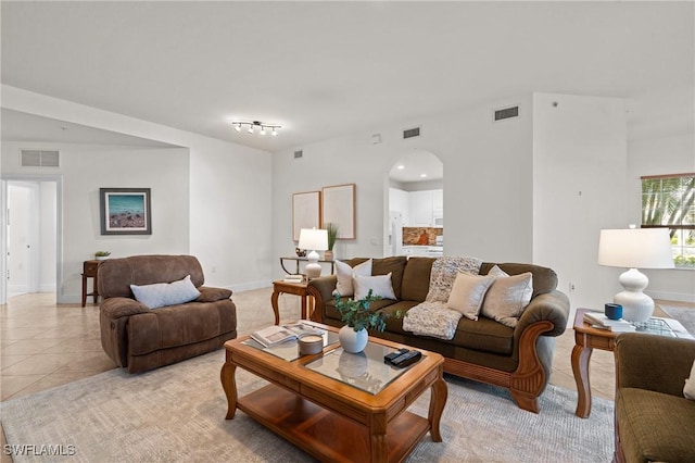 9083 Cascada Way Unit 101, Naples, FL 34114 - living room featuring light tile patterned flooring, arched walkways, and baseboards