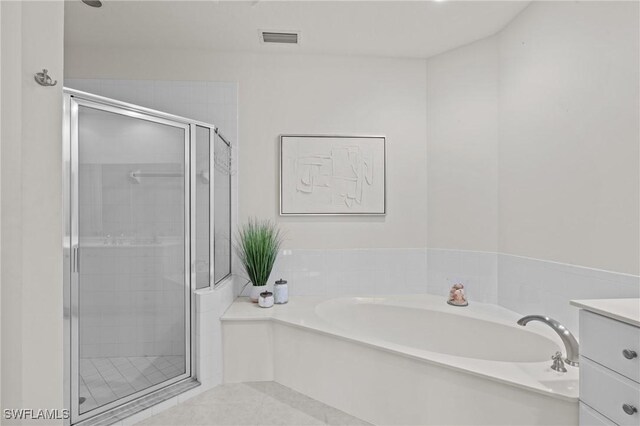 9083 Cascada Way Unit 101, Naples, FL 34114 - bathroom featuring a shower stall, a bath, tile patterned floors, and vanity