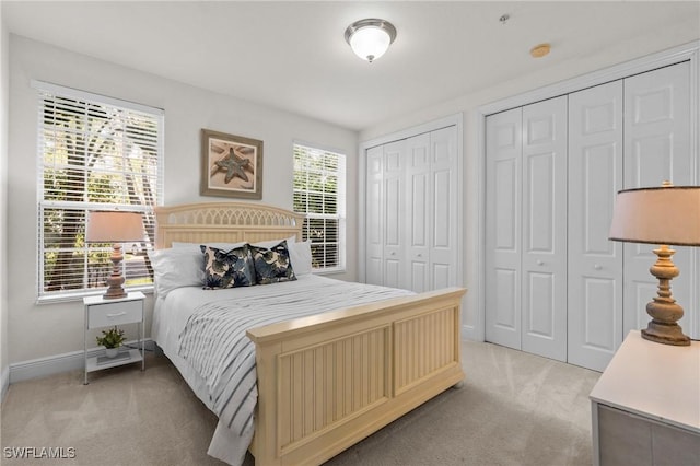 9083 Cascada Way Unit 101, Naples, FL 34114 - bedroom with light carpet, multiple closets, and baseboards