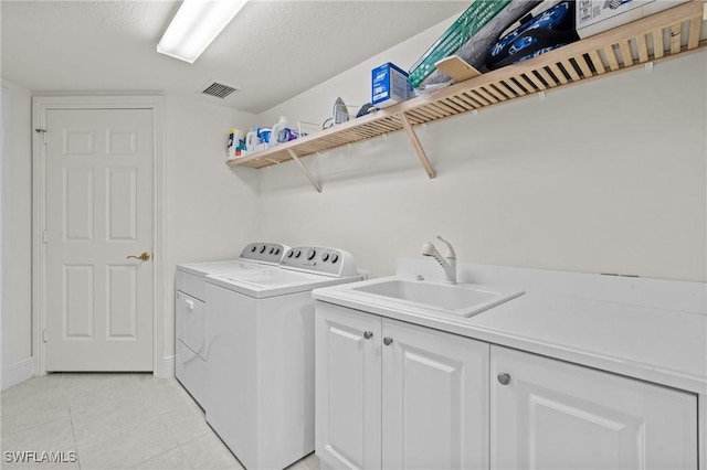 9083 Cascada Way Unit 101, Naples, FL 34114 - laundry area with independent washer and dryer, cabinet space, light tile patterned floors, and a textured ceiling