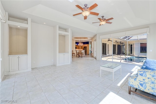 interior space featuring light tile patterned floors, a raised ceiling, recessed lighting, and ceiling fan with notable chandelier