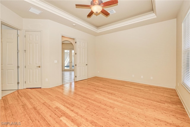 unfurnished bedroom featuring ornamental molding, light wood-style floors, and visible vents