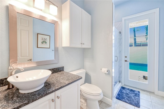 full bathroom with a stall shower, baseboards, toilet, tile patterned floors, and vanity