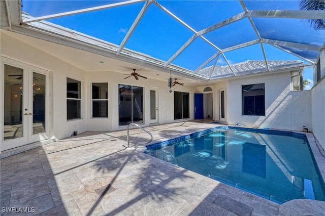 outdoor pool with ceiling fan, a patio, french doors, and glass enclosure