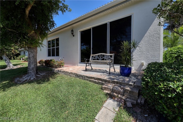 rear view of property with a yard and stucco siding