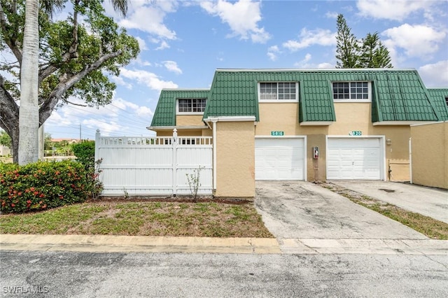 5816 Whiting Ct, Fort Myers, FL 33919 - view of front of house with stucco siding, concrete driveway, mansard roof, and fence