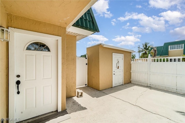5816 Whiting Ct, Fort Myers, FL 33919 - doorway to property featuring stucco siding, a patio area, and fence