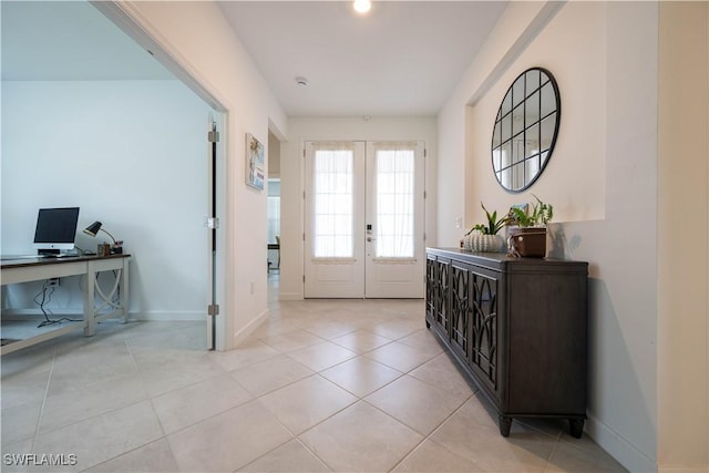 foyer entrance with baseboards, french doors, and light tile patterned flooring