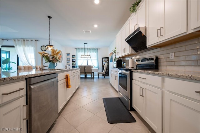 kitchen featuring appliances with stainless steel finishes, backsplash, wall chimney exhaust hood, white cabinetry, and light tile patterned floors