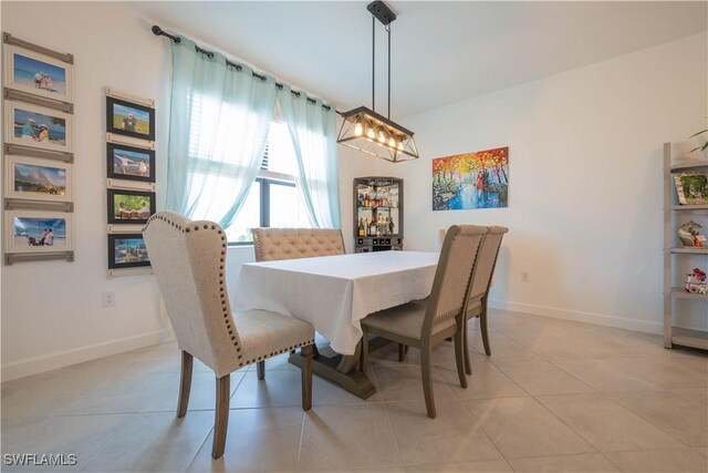 dining area with baseboards and light tile patterned flooring