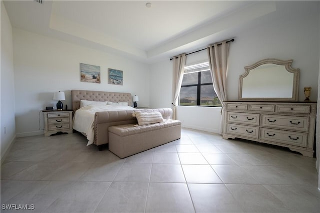 bedroom with light tile patterned flooring, baseboards, and a raised ceiling