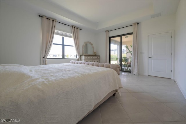 bedroom featuring light tile patterned floors, multiple windows, access to outside, and a tray ceiling