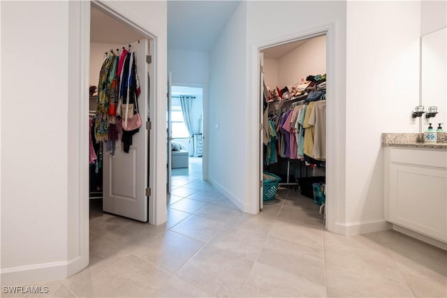 interior space with light tile patterned floors and baseboards