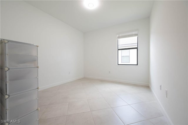 unfurnished room with baseboards and light tile patterned floors