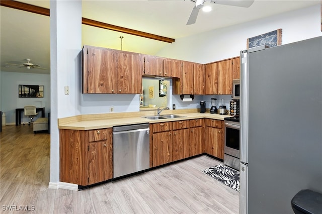 kitchen with ceiling fan, a sink, appliances with stainless steel finishes, and vaulted ceiling with beams