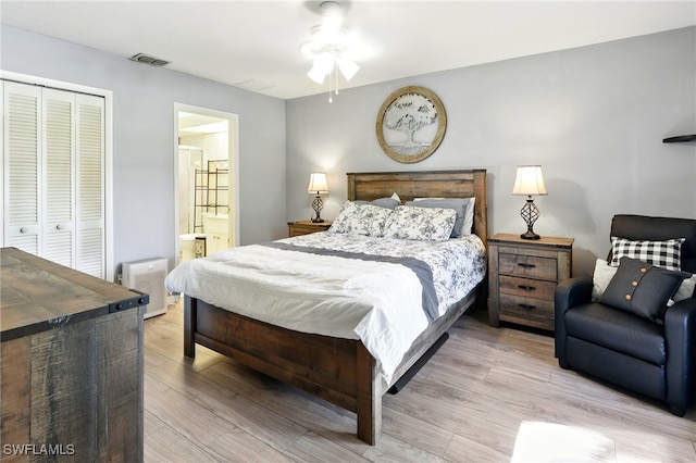 bedroom featuring ensuite bathroom, a closet, light wood-style flooring, and visible vents