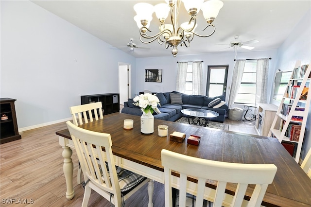 dining room featuring light wood finished floors, ceiling fan with notable chandelier, and baseboards