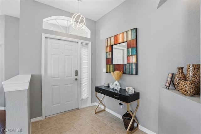 foyer entrance featuring baseboards and a chandelier