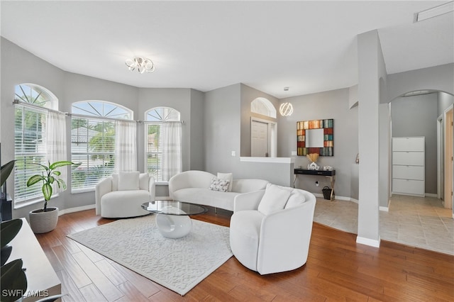 living room featuring arched walkways, healthy amount of natural light, and wood finished floors