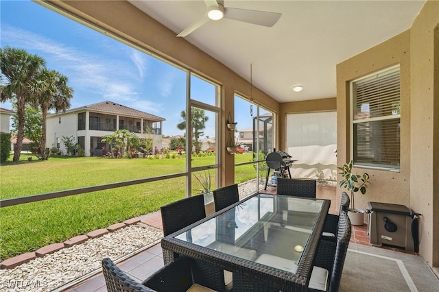 sunroom with a ceiling fan and outdoor dining area