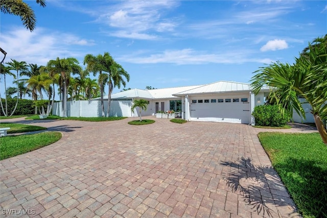 6953 Wittman Dr, Fort Myers, FL 33919 - ranch-style house with curved driveway, an attached garage, and metal roof