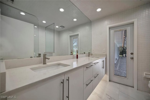 6953 Wittman Dr, Fort Myers, FL 33919 - bathroom featuring double vanity, marble finish flooring, tile walls, and recessed lighting