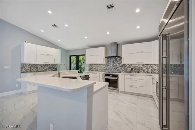 6953 Wittman Dr, Fort Myers, FL 33919 - kitchen with wall chimney range hood, a sink, appliances with stainless steel finishes, light marble finish flooring, and vaulted ceiling