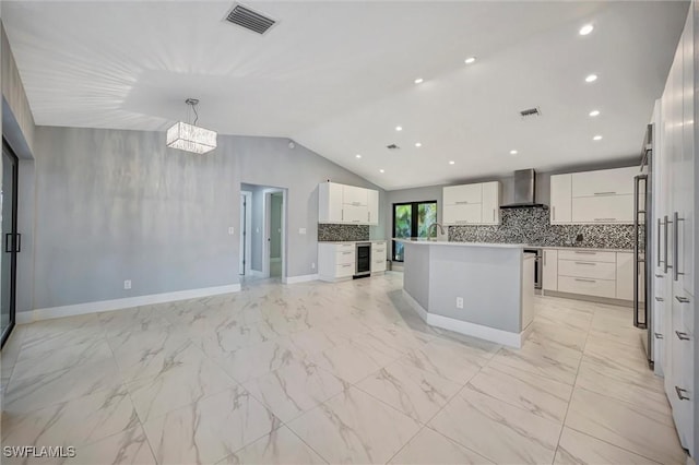 6953 Wittman Dr, Fort Myers, FL 33919 - kitchen with wall chimney range hood, beverage cooler, backsplash, vaulted ceiling, and modern cabinets